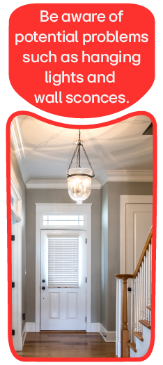 A staircase with a low-hanging ceiling light.  Be aware of potential problems such as hanging lights and wall sconces.